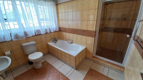 uma casa de banho com um WC, um chuveiro e um lavatório. em Huisie Langs Die See em Swakopmund