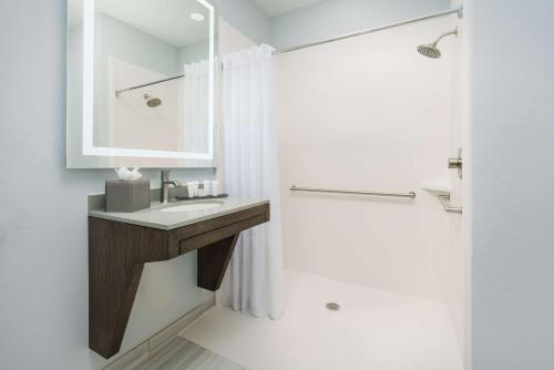 a bathroom with a sink and a mirror and a shower at The Bluff Hotel Savannah, Tapestry Collection by Hilton in Savannah