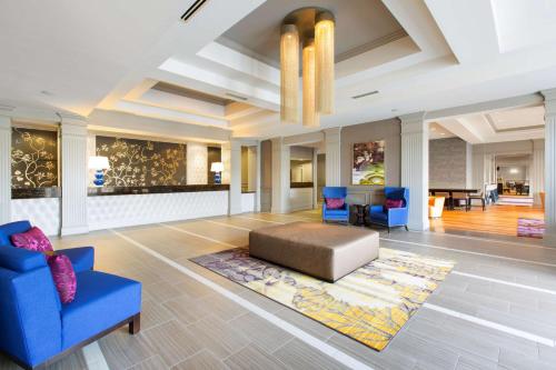a living room with blue chairs and a couch at DoubleTree by Hilton Historic Savannah in Savannah