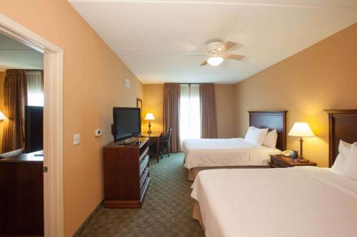 a hotel room with two beds and a flat screen tv at Homewood Suites by Hilton San Antonio North in San Antonio