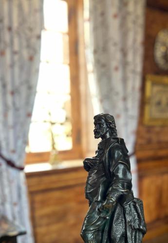 a bronze statue of a woman holding a purse at Château de La Rivière in Pontgouin