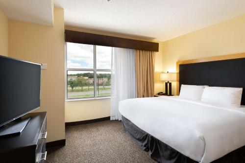 a hotel room with a bed and a large window at DoubleTree by Hilton Hotel Savannah Airport in Savannah