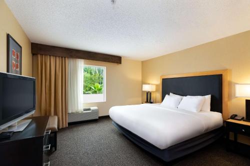 a hotel room with a large bed and a flat screen tv at DoubleTree by Hilton Hotel Savannah Airport in Savannah