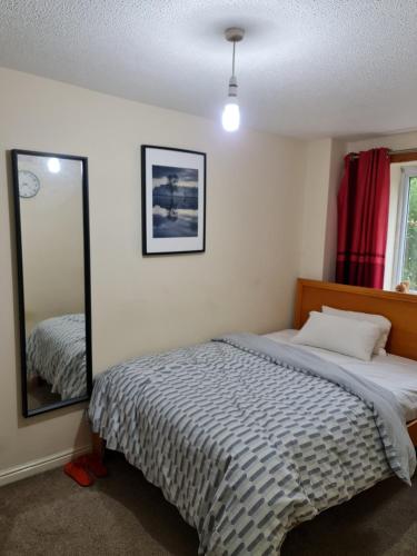 een slaapkamer met een bed en een spiegel bij Curly Curves in North Woolwich