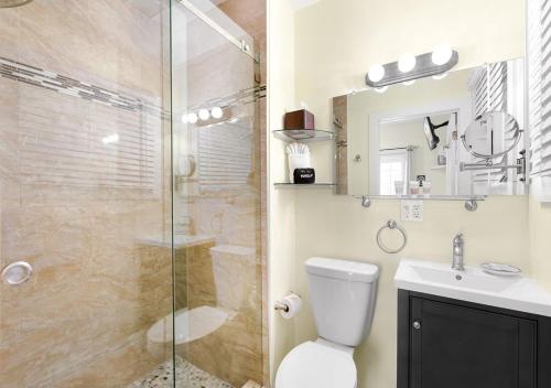 a bathroom with a shower and a toilet and a sink at The Grand Guesthouse in Key West
