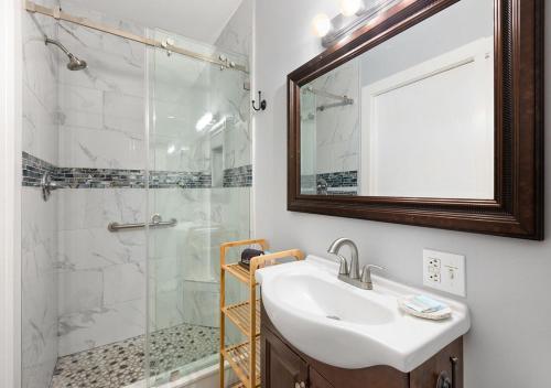 a bathroom with a sink and a shower with a mirror at The Grand Guesthouse in Key West