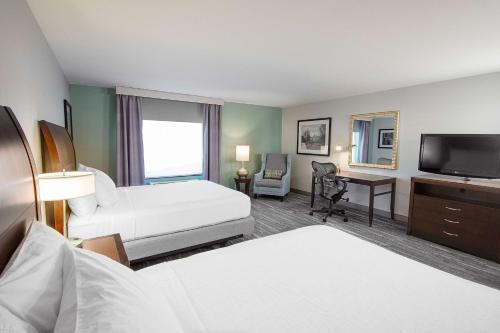 a hotel room with two beds and a flat screen tv at Hilton Garden Inn South Bend in South Bend