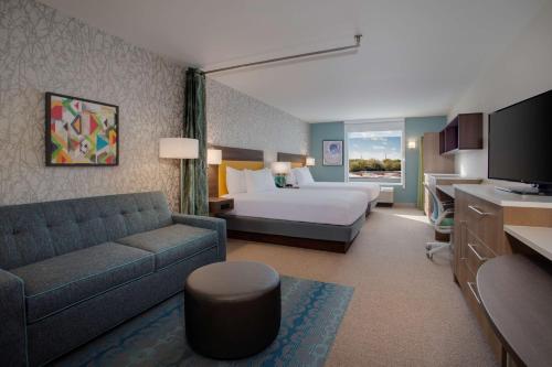 a hotel room with a bed and a couch at Home2 Suites By Hilton Lewes Rehoboth Beach in Lewes
