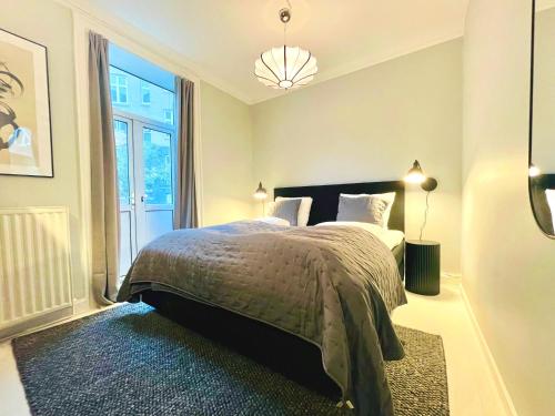 a bedroom with a bed and a large window at Amazing Flat in Urban Neighborhood in Copenhagen