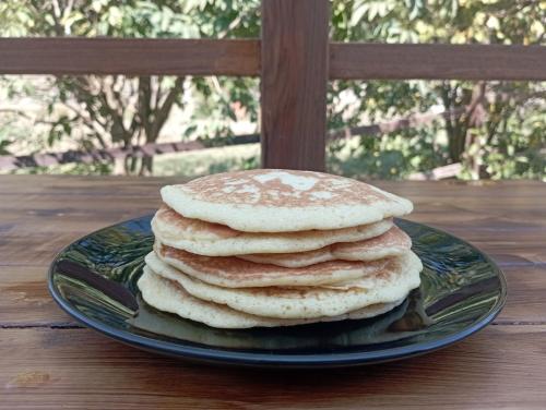 a stack of pancakes on a plate on a table at LA TANA DELLA VOLPETTA - Bed & Breakfast in Stella