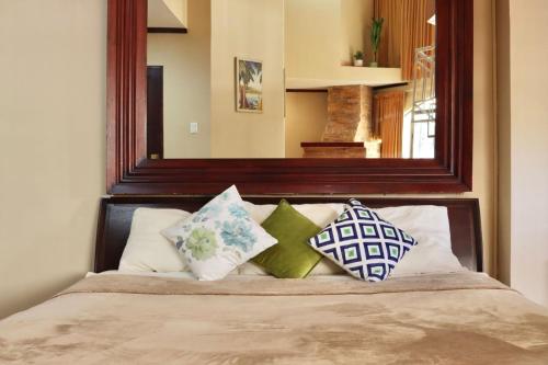 サンホセにあるHotel La Amistadのベッド(枕付)、鏡