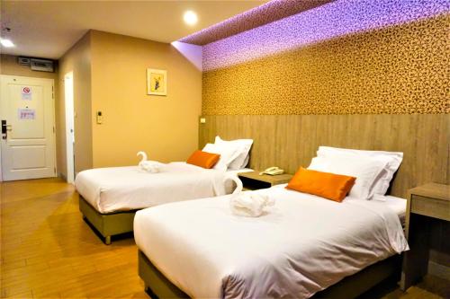um quarto de hotel com duas camas com toalhas em Nest n Rest Hotel em Ban Bang Toei (1)