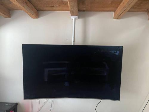 a flat screen tv hanging on a white wall at Bikers Paradise Apartment in Oberlängenfeld