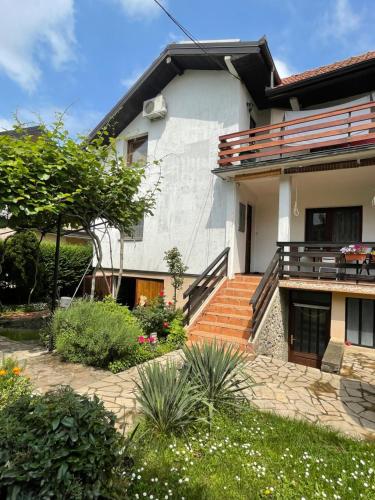 a house with stairs and plants in front of it at 5min Airport in Surčin