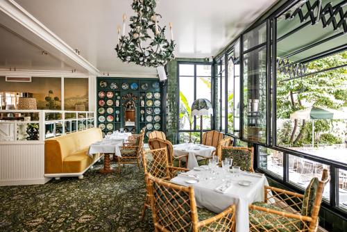 a restaurant with tables and chairs and a chandelier at Hôtel Eldorado Paris in Paris
