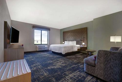 PattersonHampton Inn Patterson, Ca的一间带床和椅子的酒店房间