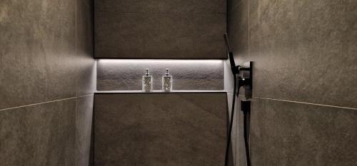 a bathroom with a mirror and two bottles on a shelf at Privat-Spa mit Whirlpool und Sauna in Sursee in Sursee