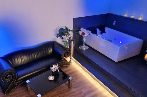 uma sala de estar com um sofá de couro preto e uma banheira em Privat-Spa mit Whirlpool und Sauna in Sursee em Sursee