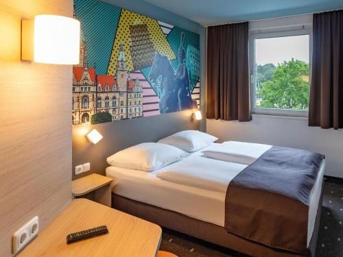a hotel room with a bed and a window at B&B Hotel Hannover-Lahe in Hannover