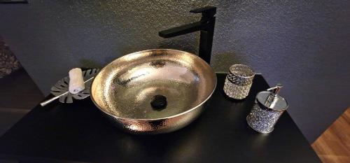 a metal sink on top of a black counter at Privat-Spa mit Whirlpool und Sauna in Sursee in Sursee
