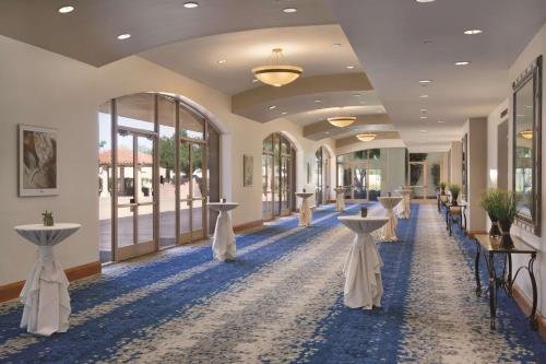 a hallway with tables and chairs in a building at Embassy Suites by Hilton Scottsdale Resort in Scottsdale