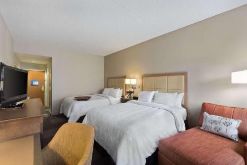 Hampton Inn & Suites Phoenix/Scottsdale في سكوتسديل: غرفة فندقية بسريرين وتلفزيون بشاشة مسطحة