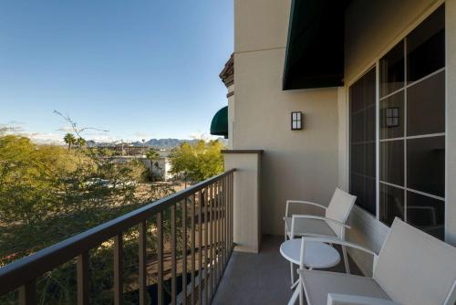 a balcony with white chairs and a view at Hampton Inn & Suites Phoenix/Scottsdale in Scottsdale