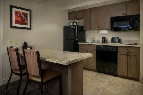 a kitchen with a counter and a black refrigerator at Hampton Inn & Suites Phoenix/Scottsdale in Scottsdale