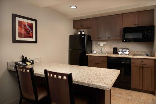 a kitchen with a counter and a black refrigerator at Hampton Inn & Suites Phoenix/Scottsdale in Scottsdale