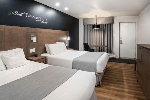 um quarto de hotel com duas camas e uma mesa em Hôtel Marineau La Tuque em La Tuque