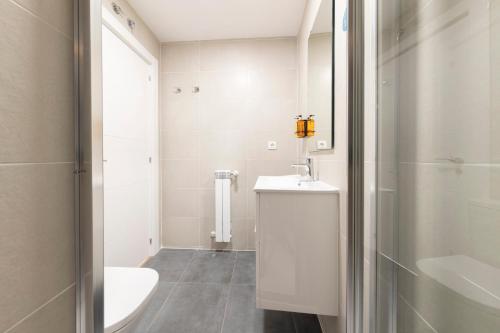 a white bathroom with a sink and a toilet at DWO Ábaster Suites in Soria