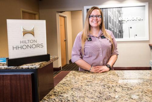 a woman standing behind a counter in a hotel room at Hampton Inn Clarksville in Clarksville