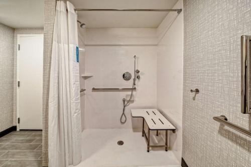 baño blanco con ducha y lavamanos en Hampton Inn New Albany Louisville West, en New Albany