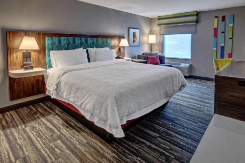 a hotel room with a large bed and a desk at Hampton Inn New Albany Louisville West in New Albany