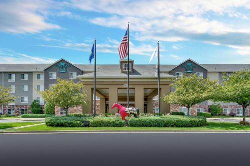 a hotel with flags in front of a building at Homewood Suites by Hilton Louisville-East in Louisville