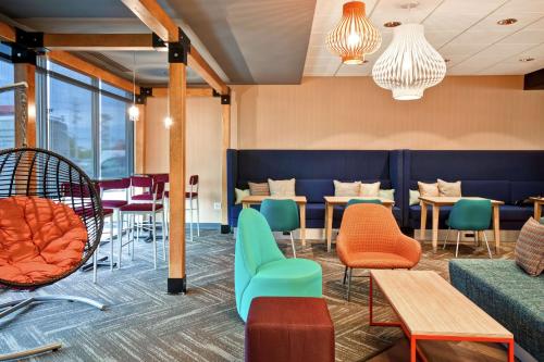 a waiting room with colorful chairs and tables at Tru By Hilton Louisville Airport in Louisville