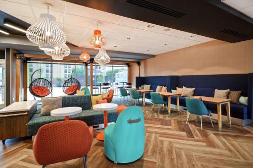 a lobby with tables and chairs and a couch at Tru By Hilton Louisville Airport in Louisville