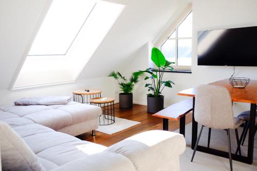 a living room with white furniture and a flat screen tv at Trautesheim Ferienwohnungen in Wangen im Allgäu