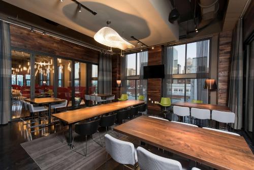 a restaurant with wooden tables and chairs and windows at Hilton Garden Inn Louisville Downtown in Louisville