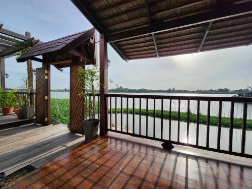 a wooden deck with a view of the water at RuenKijja in Ban Kroen