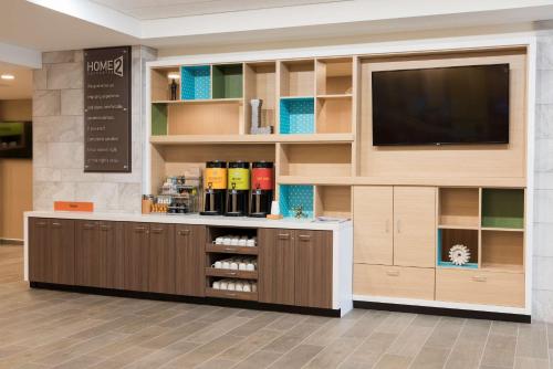 a pharmacyacist with a flat screen tv on a wall at Home2 Suites by Hilton Louisville Downtown NuLu in Louisville