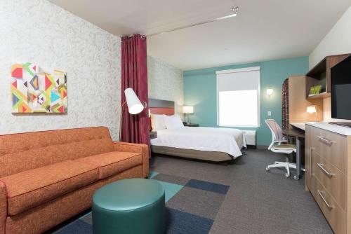 una camera d'albergo con letto e divano di Home2 Suites by Hilton Louisville Downtown NuLu a Louisville