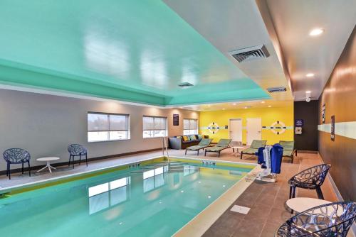 a pool in a hotel room with chairs and a living room at Tru By Hilton Shepherdsville Louisville South in Shepherdsville