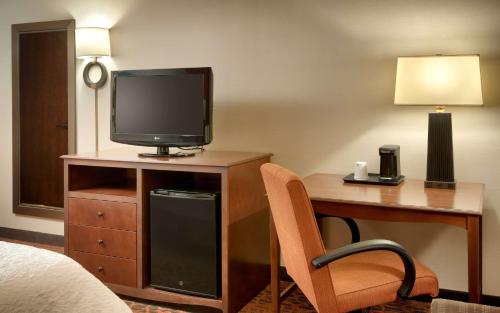 a hotel room with a desk with a television and a bed at Hampton Inn Salt Lake City/Sandy in Sandy