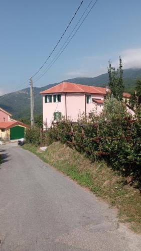 a pink house on the side of a road at LA TANA DELLA VOLPETTA - Bed & Breakfast in Stella