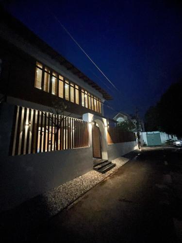 un bâtiment éclairé la nuit avec une porte dans l'établissement Willage Mai, à Ấp Bình Hưng