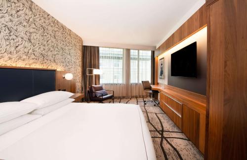 a hotel room with a bed and a flat screen tv at The Charter Hotel Seattle, Curio Collection By Hilton in Seattle