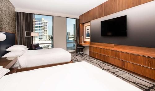 um quarto de hotel com duas camas e uma televisão de ecrã plano em The Charter Hotel Seattle, Curio Collection By Hilton em Seattle