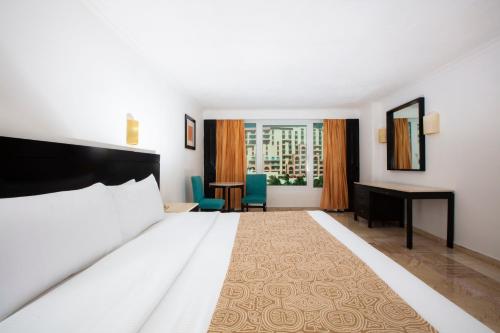 a hotel room with a bed and a desk at Krystal Cancun in Cancún