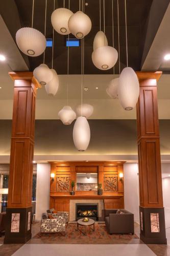 a living room with several chandeliers and a fireplace at Hilton Garden Inn Seattle/Issaquah in Issaquah